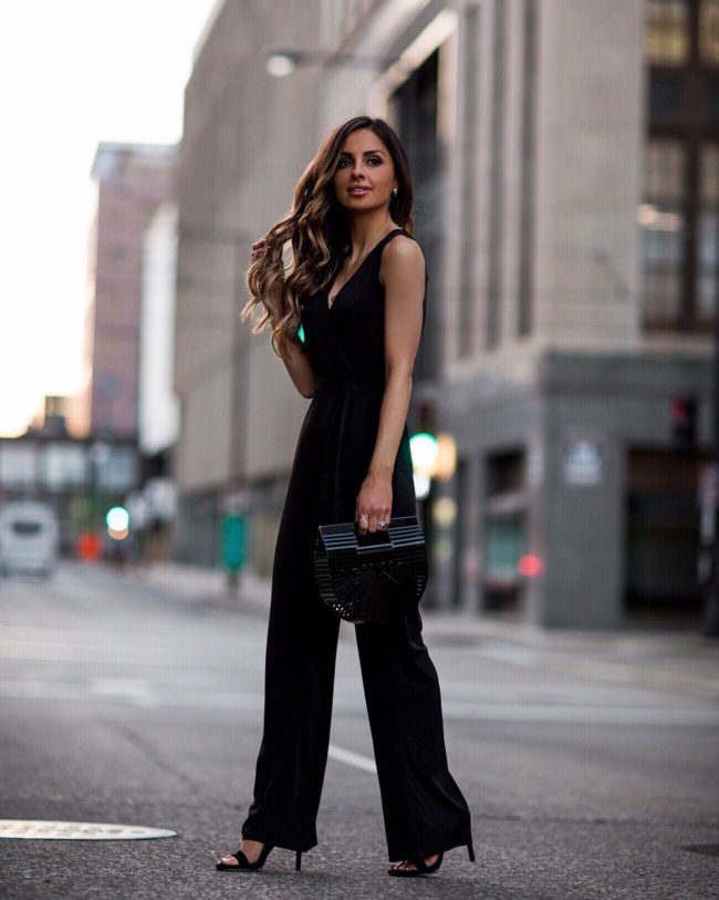fashion blogger mia mia mine wearing a black jumpsuit from macys