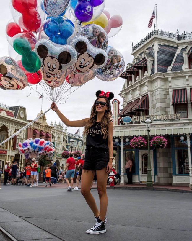 fashion blogger mia mia mine wearing a balmain top and converse sneakers at disney world