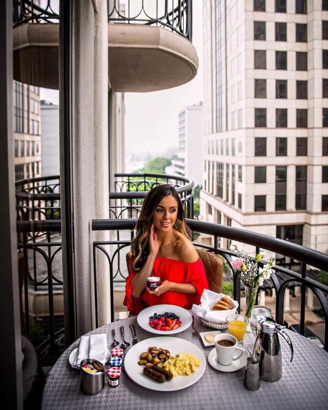 fashion blogger mia mia mine wearing a red romper eating breakfast
