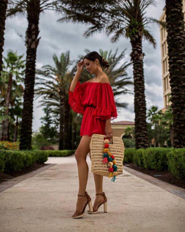 fashion blogger mia mia mine wearing a red romper from revolve at the four seasons orlando