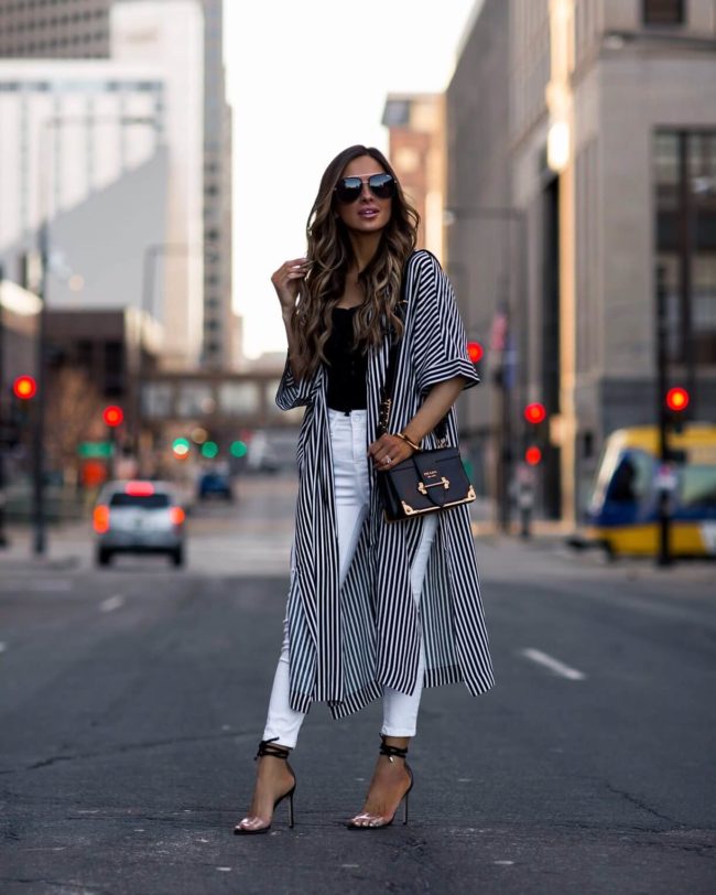 fashion blogger mia mia mine wearing a black and white striped kimono and white denim