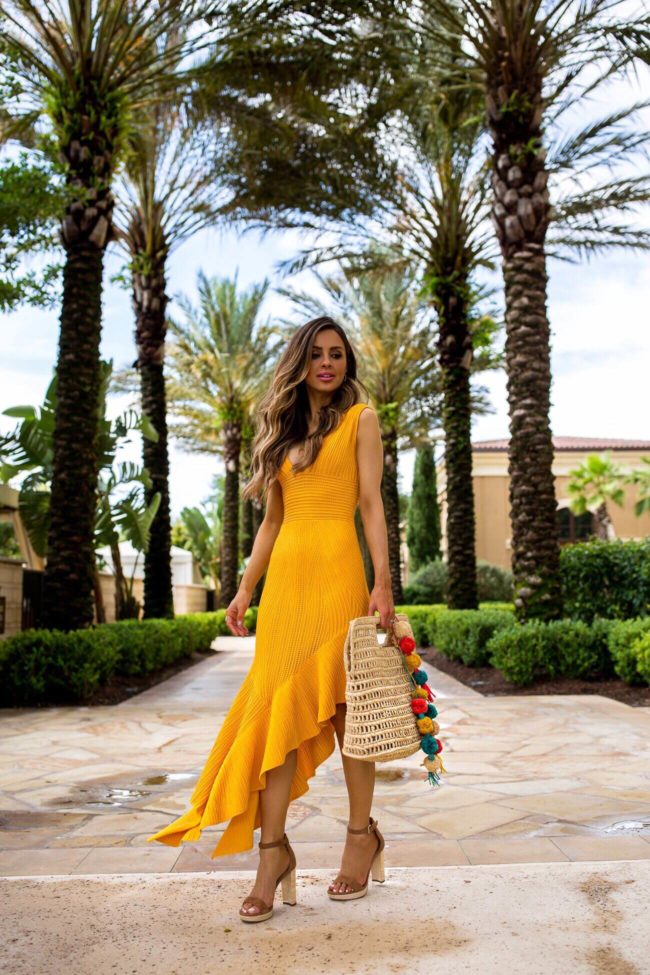 fashion blogger mia mia mine wearing a yellow dress in orlando at the four season disney resort