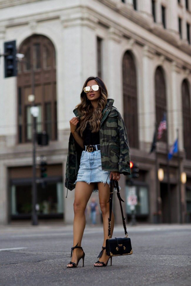 fashion blogger mia mia mine wearing a camo jacket by alpha industries and a gucci double g buckle belt