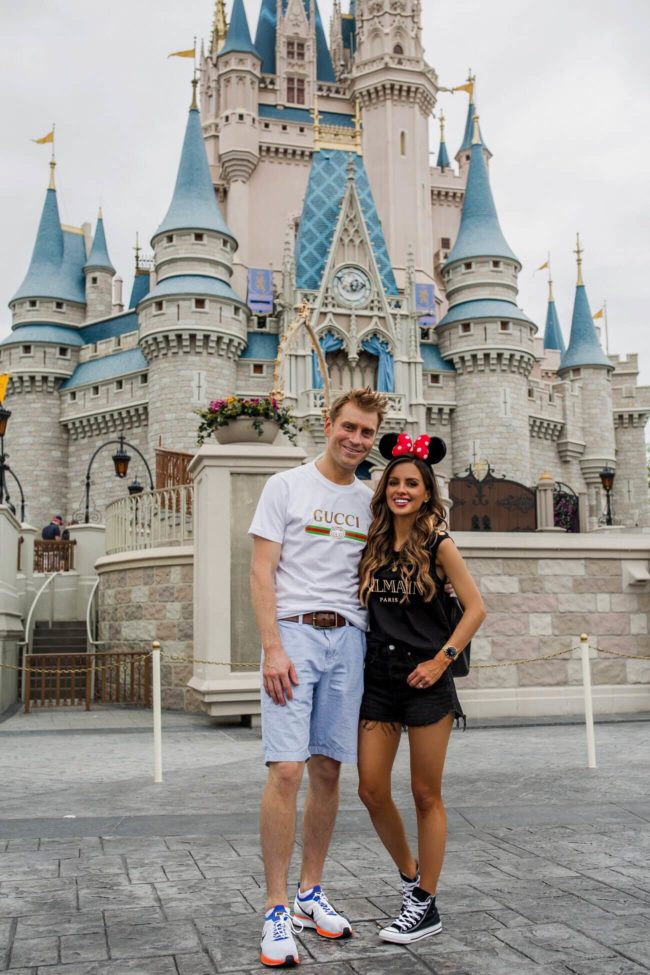 fashion blogger mia mia mine wearing a balmain shirt and converse sneakers at disney world