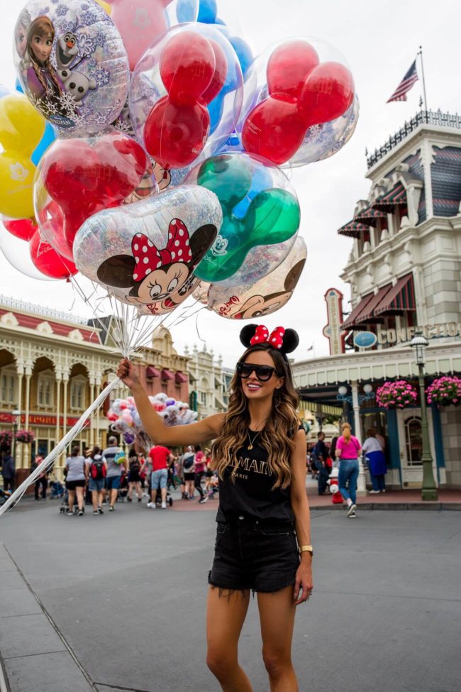 fashion blogger mia mia mine wearing a balmain tee at disney world's magic kingdom