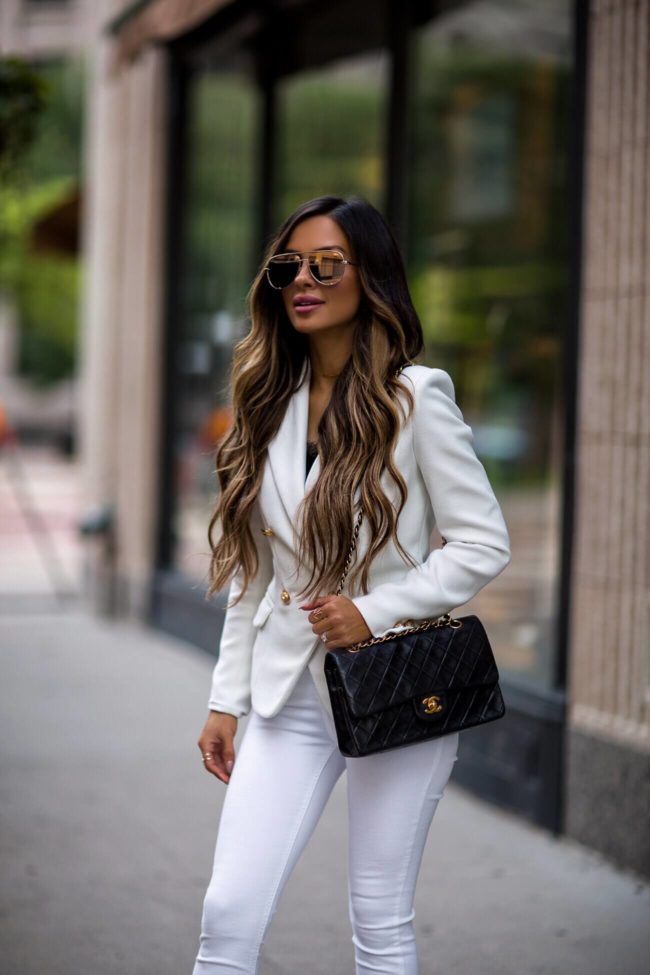 fashion blogger mia mia mine wearing a white lioness blazer and a chanel bag