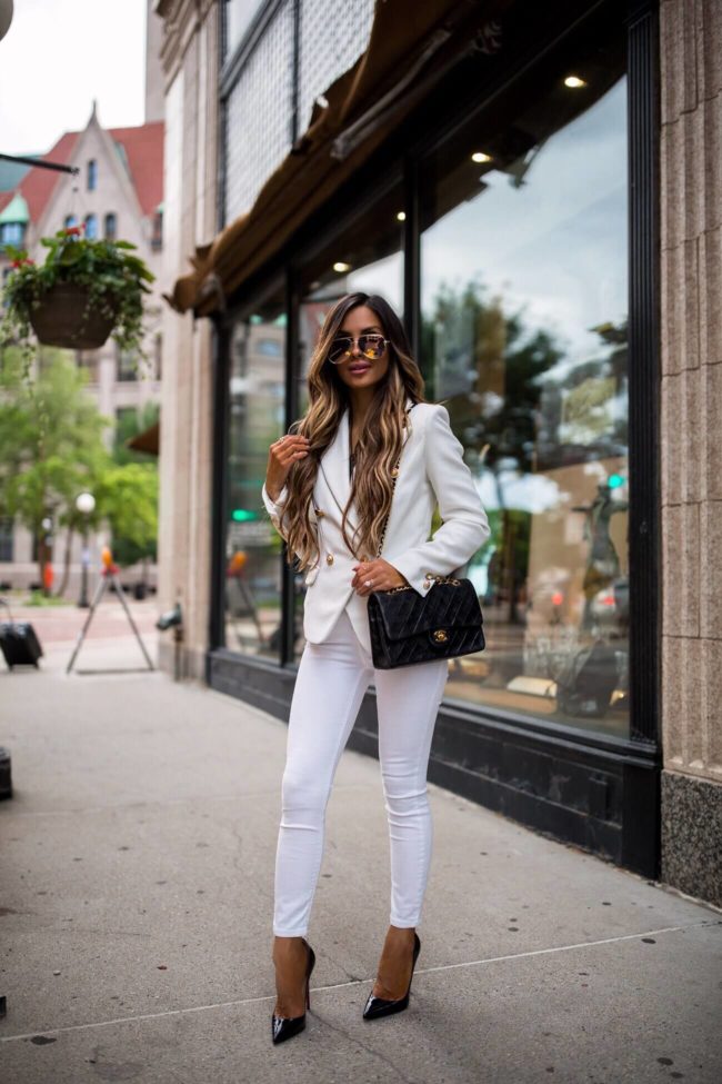 fashion blogger mia mia mine wearing a white blazer and a chanel bag