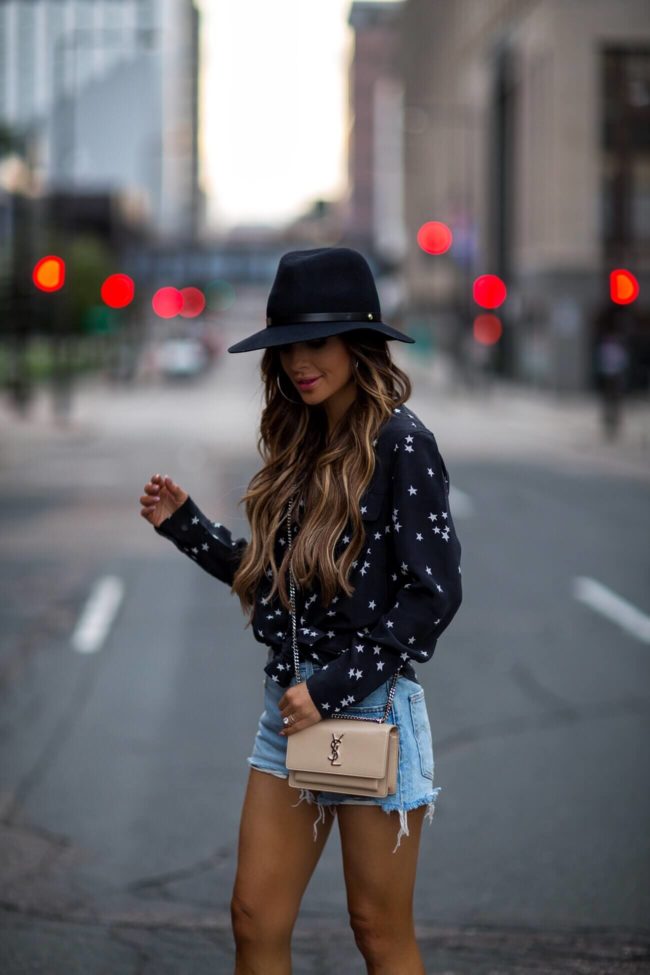 fashion blogger mia mia mine wearing a black fedora hat and a saint laurent sunset crossbody bag