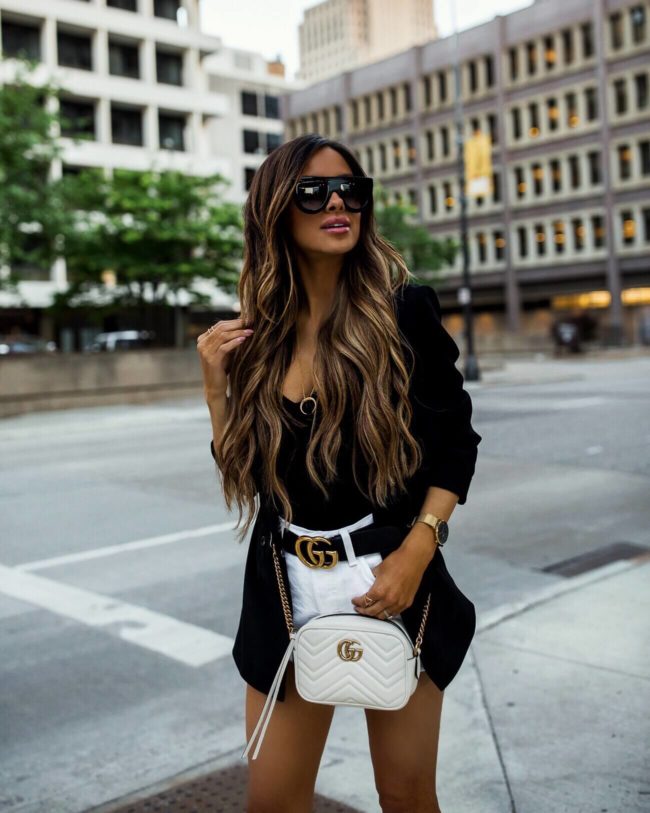 fashion blogger mia mia mine wearing a black blazer and white denim levi's short from nordstrom