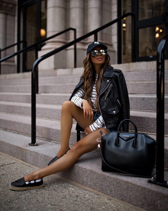 fashion blogger mia mia mine wearing a leather jacket and NY baseball cap