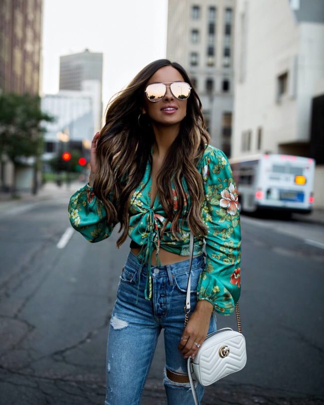 fashion blogger mia mia mine wearing a floral green satin top and high-rise denim from revolve