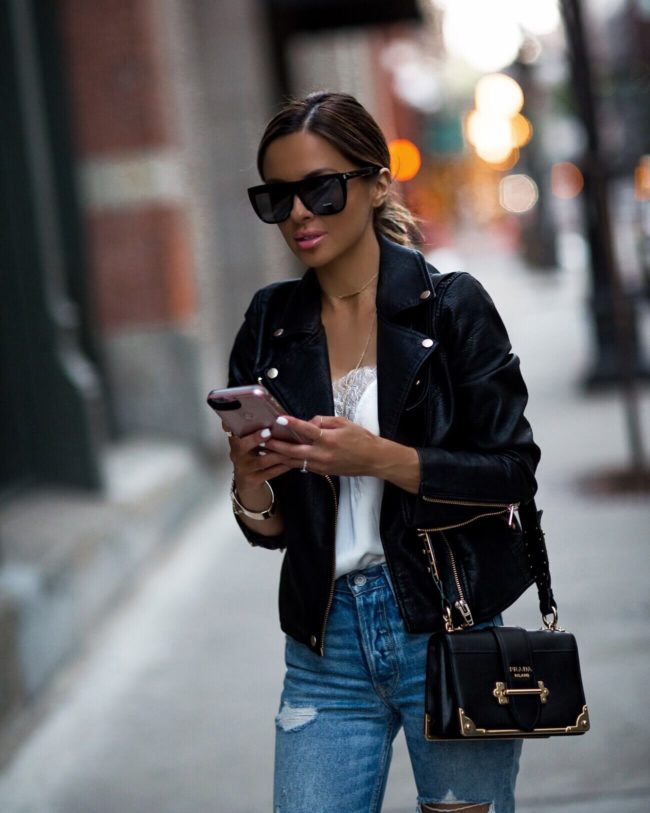 fashion blogger mia mia mine wearing a faux leather jacket and a prada cahier bag