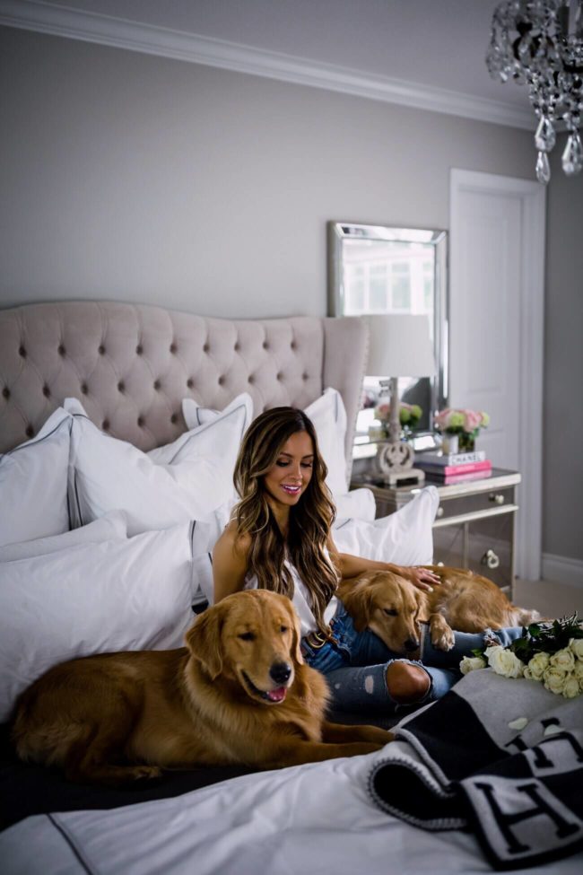 fashion blogger mia mia mine in her master bedroom with golden retrievers