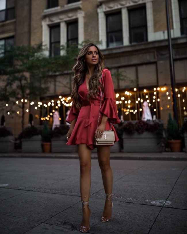fashion blogger mia mia mine wearing an orange romper and a saint laurent handbag