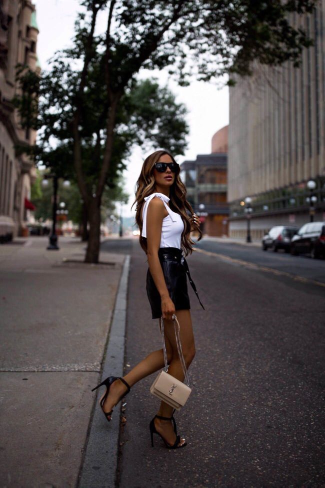 fashion blogger mia mia mine wearing a saint laurent sunset bag and a white tie tank top from revolve