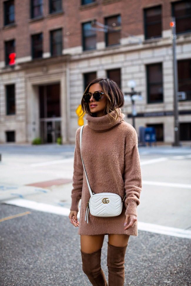 fashion blogger mia mia mine wearing a camel turtleneck sweater dress from revolve and a white gucci crossbody bag