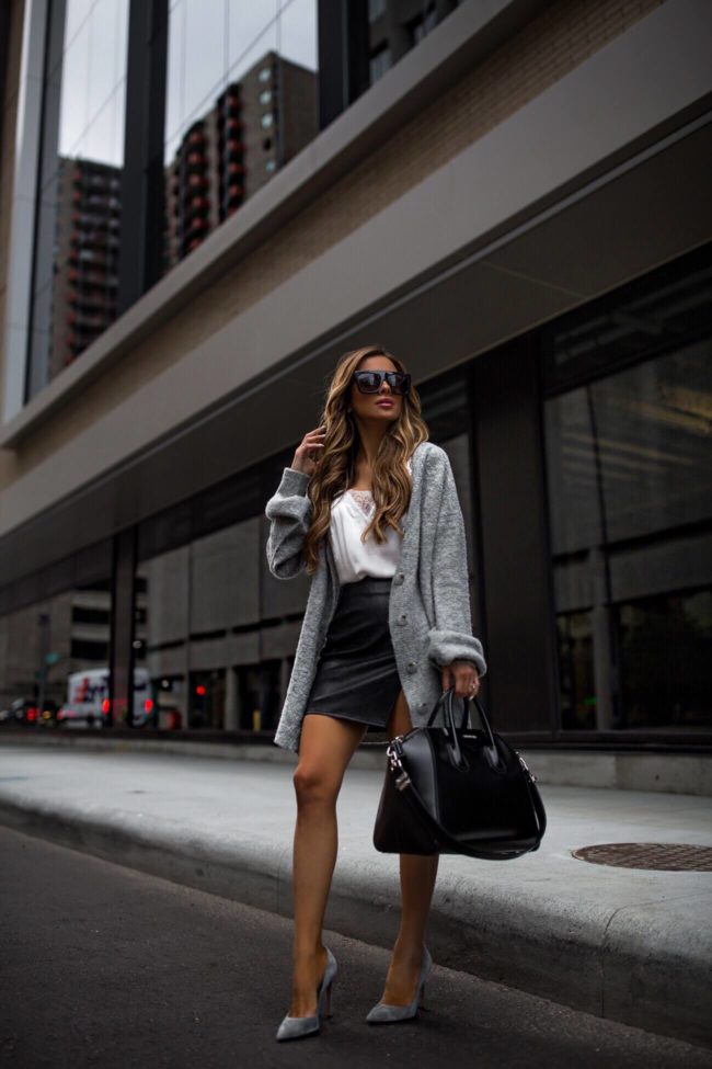 fashion blogger mia mia mine wearign a grey cardigan from revolve and a faux leather skirt