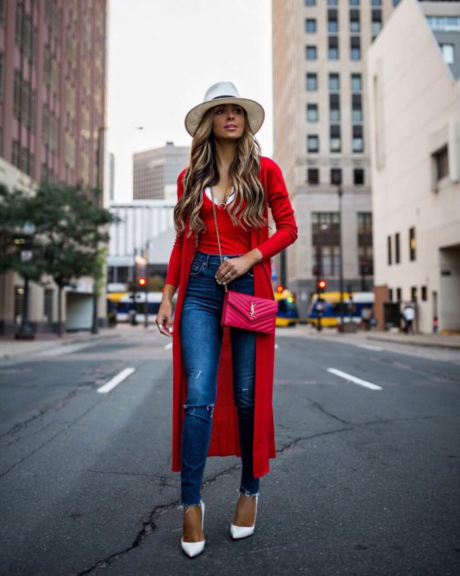 fashion blogger mia mia mine wearing a red duster sweater from revolve and a white panama hat by rag & bone