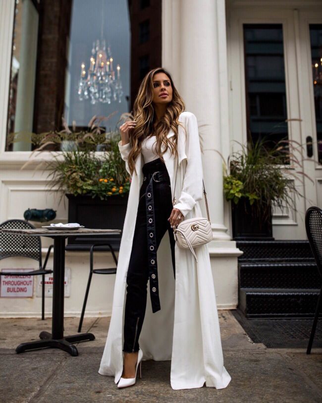 fashion blogger mia mia mine wearing a white trench coat from revolve at nyfw