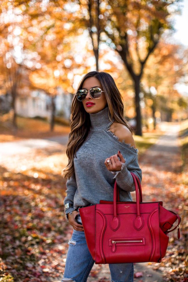 fashion blogger mia mia mine wearing a gray chunky turtleneck sweater from revolve and a red celine bag