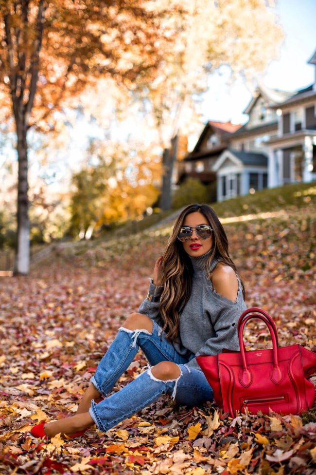 fashion blogger mia mia mine wearing a red celine luggage tote with a chunky knit turtleneck sweater