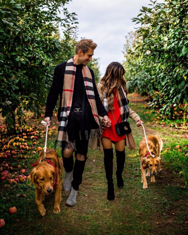 fashion blogger mia mia mine with husband phil thompson and golden retrievers at an apple orchard in minnesota