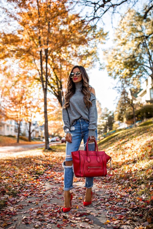 fashion blogger mia mia mine wearing a gray chunky knit turtleneck and a red celine bag
