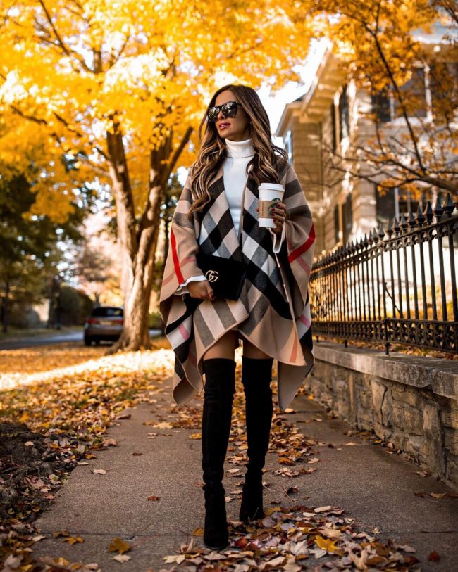 fashion blogger mia mia mine wearing a burberry poncho and a stuart weitzman over-the-knee boots