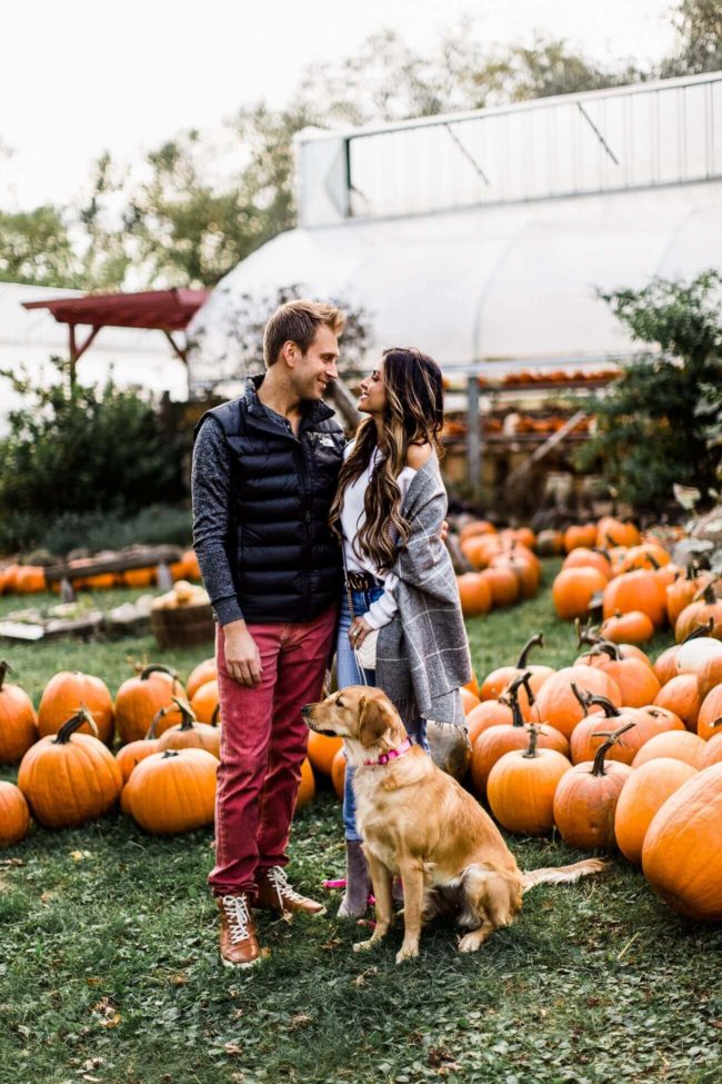 fashion blogger mia mia mine with husband and dog at a pumpkin patch in stillwater mn