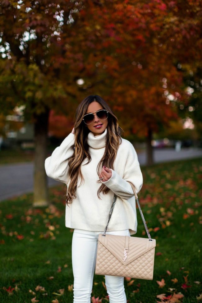 fashion blogger mia mia mine wearing a white turtleneck sweater from H&M and a saint laurent large envelope bag
