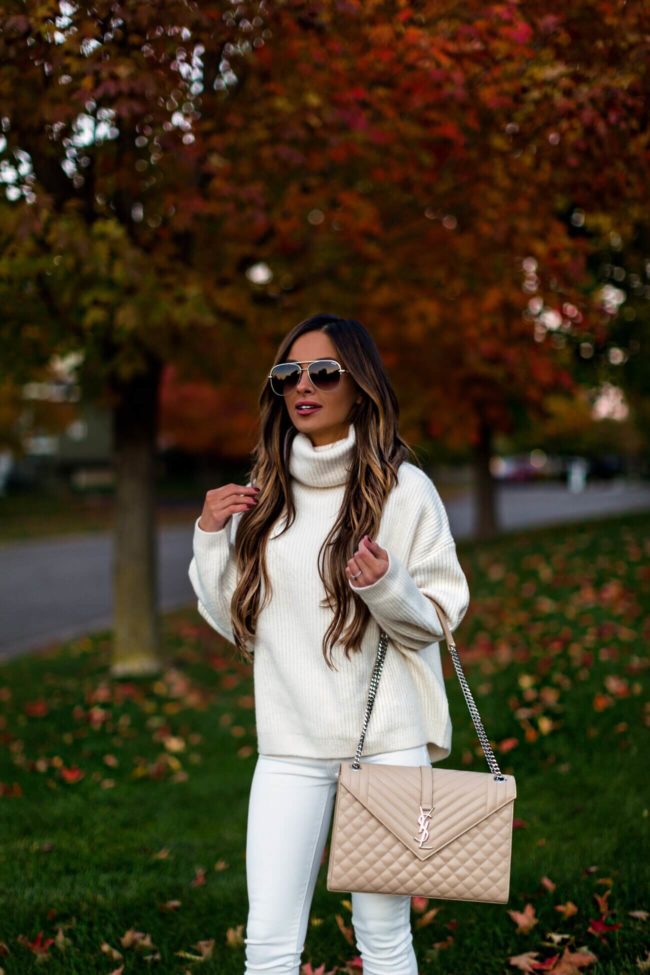 fashion blogger mia mia mine wearing a white turtleneck sweater and white denim for fall 2018