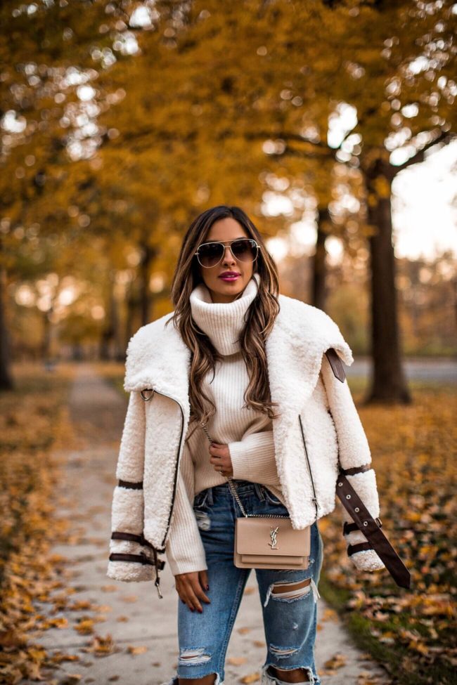 fashion blogger mia mia mine wearing a sherpa jacket and a chunky turtleneck sweater