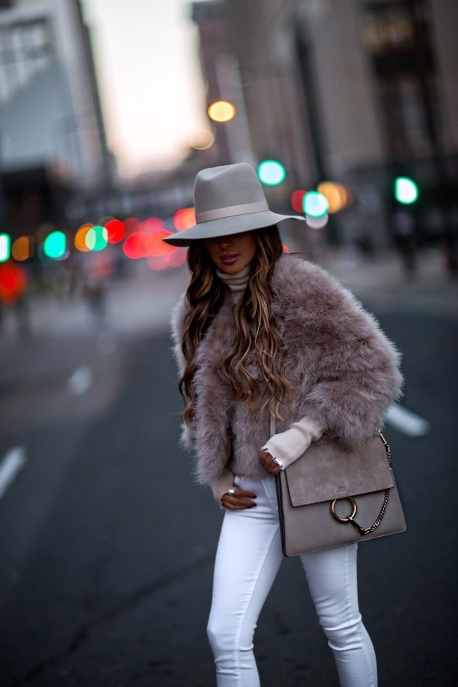 fashion blogger mia mia mine wearing a pink feather bolero and a chloe faye bag for winter