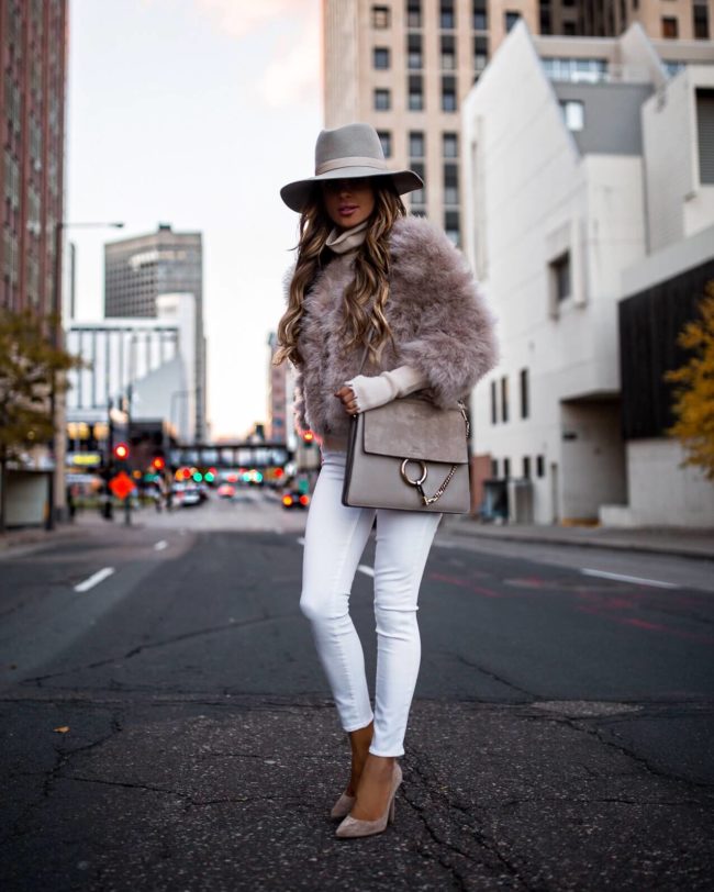fashion blogger mia mia mine wearing a pink faux fur jacket and white jeans for winter 2018
