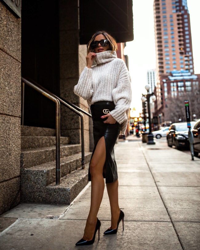 fashion blogger mia mia mine wearing a chunky turtleneck free people sweater and a black faux leather slit skirt from revolve