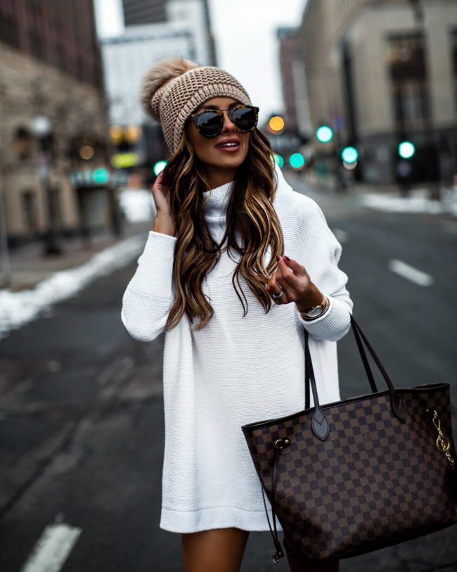 fashion blogger mia mia mine wearing a white tunic sweater and a louis vuitton bag
