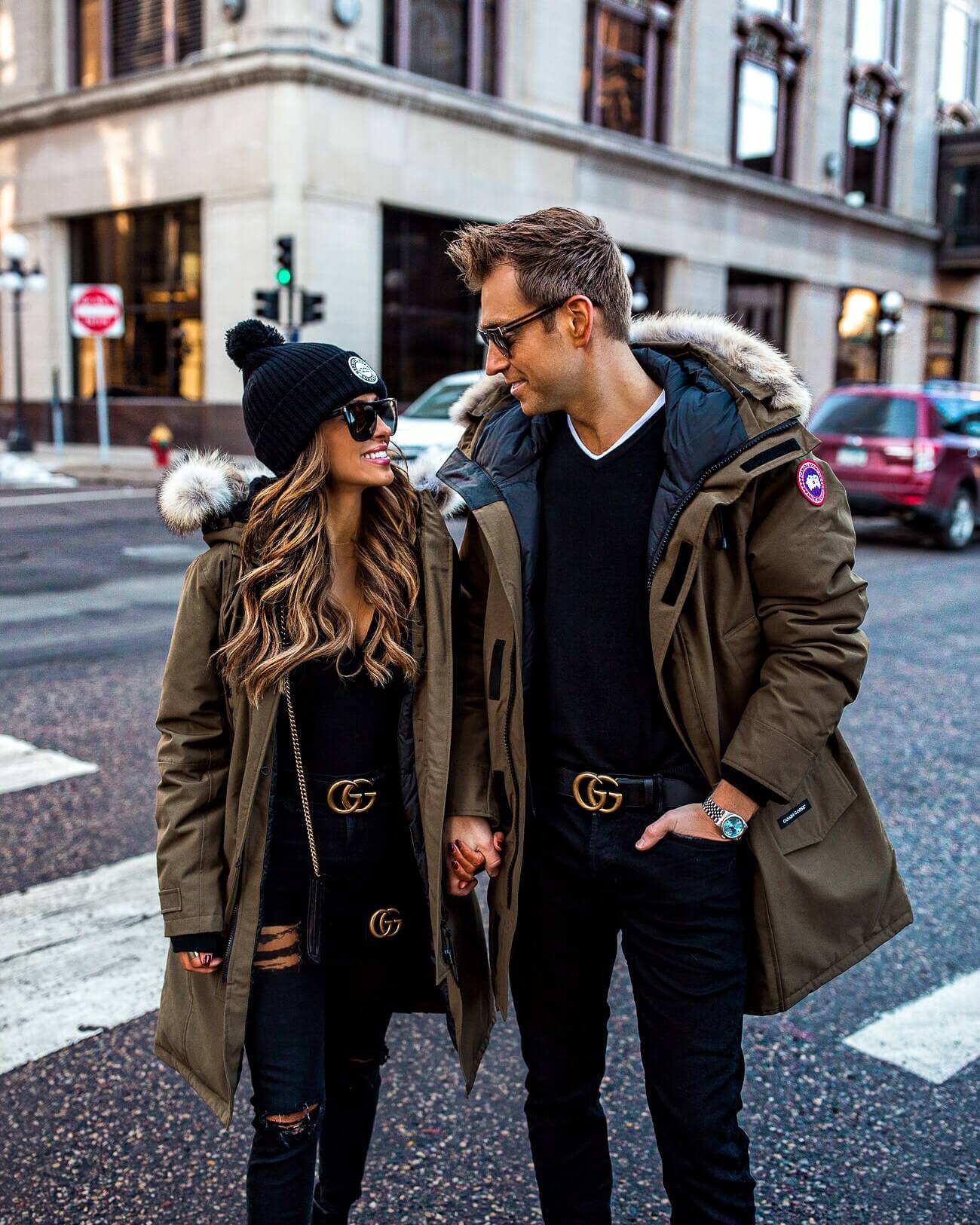 fashion blogger mia mia mine with husband phil thompson wearing matching canada goose jackets and gucci belts for holiday 2018