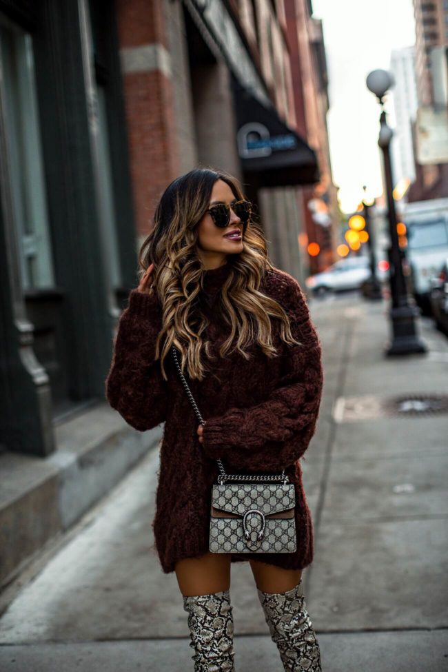 fashion blogger mia mia mine wearing a chunky brown sweater dress and over-the-knee snakeskin boots from mango