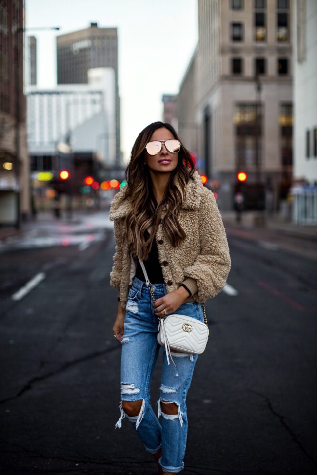 fashion blogger mia mia mine wearing a cozy teddy bear coat and ripped denim from revovle