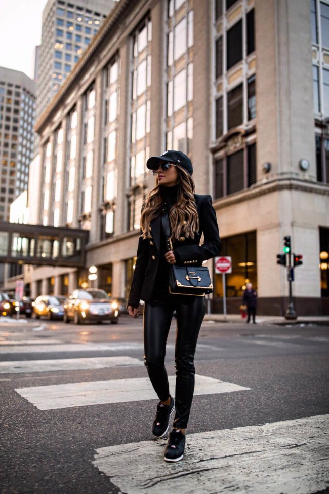 fashion blogger mia mia mine wearing a balmain blazer and a NY yankees cap