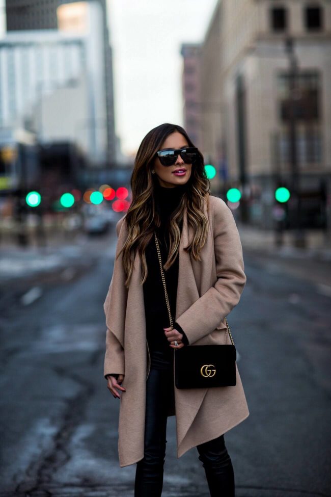 fashion blogger mia mia mine wearing a black velvet gucci marmont bag and a camel coat for winter 2019