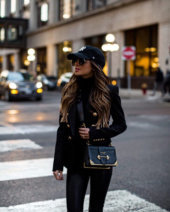 fashion blogger mia mia mine wearing a balmain blazer and a ny hat with a prada cahier bag