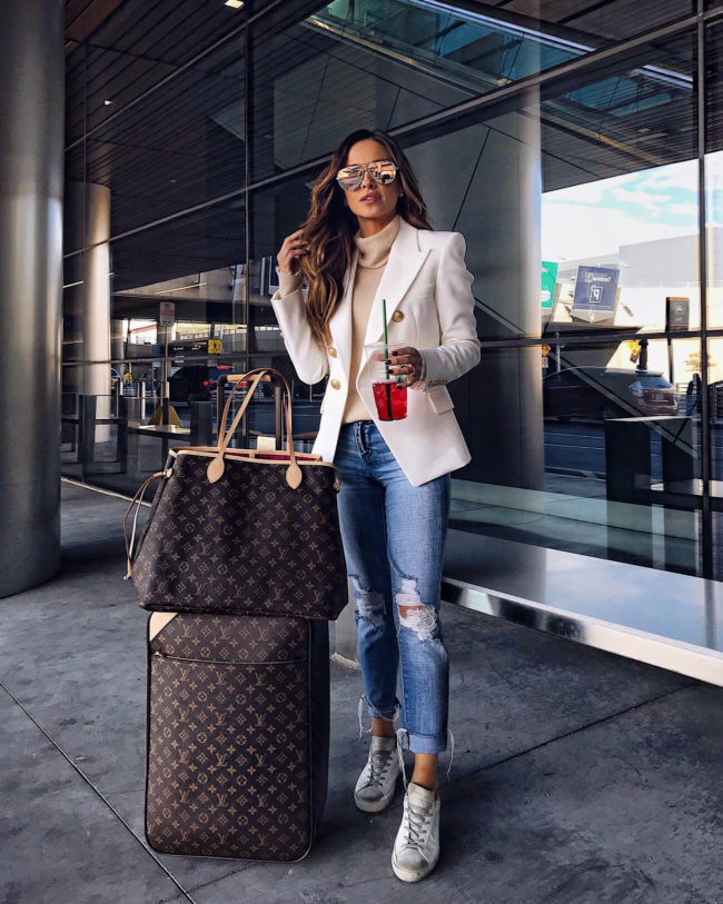 fashion blogger mia mia mine wearing a balmain blazer with louis vuitton luggage