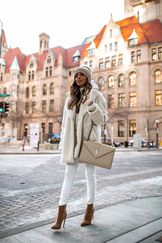 fashion blogger mia mia mine wearing a white teddy bear coat from H&M and a kyi kyi pom pom beanie from bloomingdale's