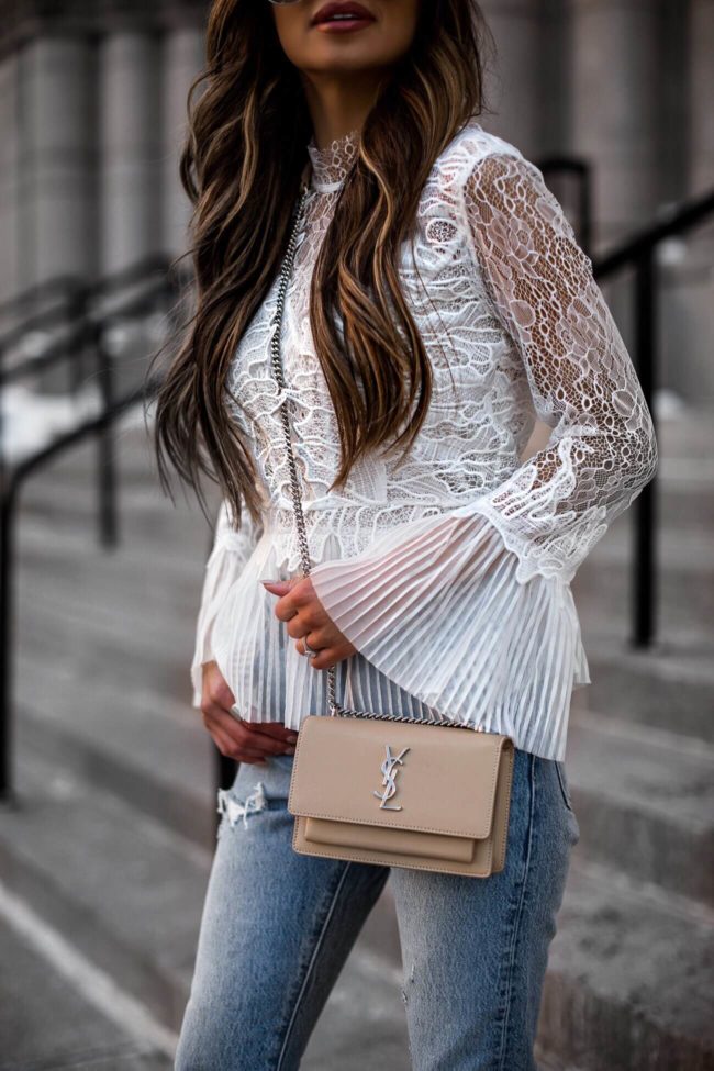 fashion blogger mia mia mine wearing a white lace top from revolve
