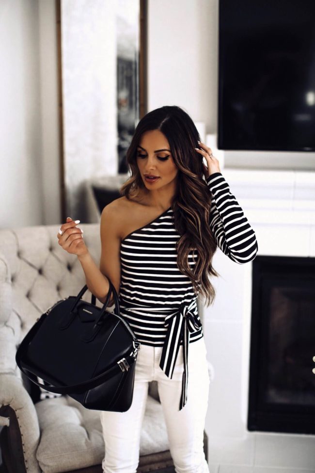 fashion blogger mia mia mine wearing a striped top and white denim at home