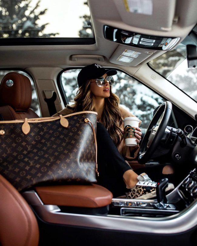 fashion blogger mia mia mine wearing a new york yankees hat and a louis vuitton neverfull bag