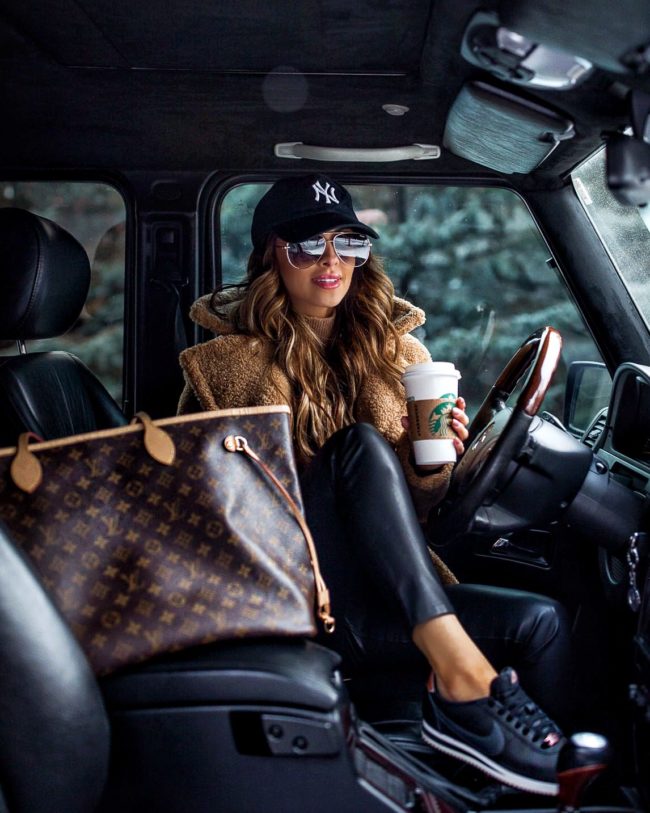 fashion blogger mia mia mine wearing a teddy bear coat and nike sneakers with a louis vuitton neverfull gm bag