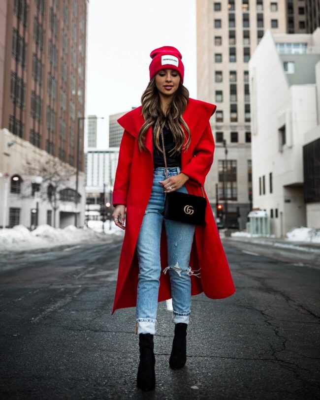 fashion blogger mia mia mine wearing a red coat and a red beanie hat for winter 2019