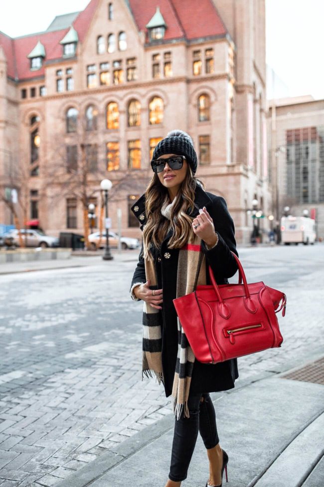fashion blogger mia mia mine wearing a pom pom beanie and a burberry scarf for winter 2019